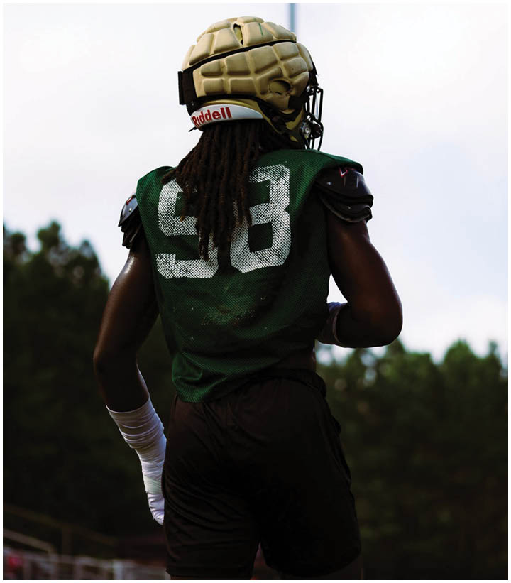A group of football players wearing black and white uniforms. Description generated by AI