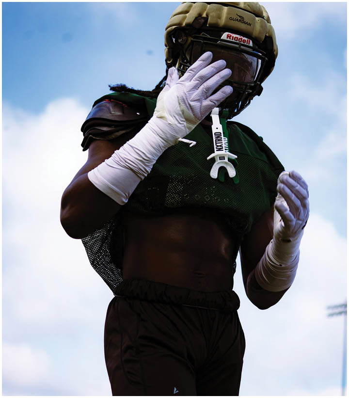 A group of football players wearing black and white uniforms. Description generated by AI