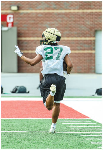 A football player running on the field. Description generated by AI