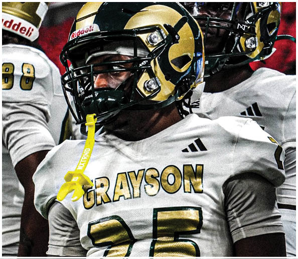 A person wearing a white football jersey with the name “GRAYSON" and the number 25 in gold and black, along with a black and gold helmet. Description generated by AI