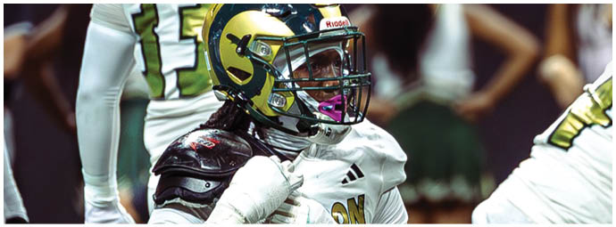 A person wearing a white and gold sports uniform with the number 24 is kneeling on a field with hands clasped near their face. Description generated by AI