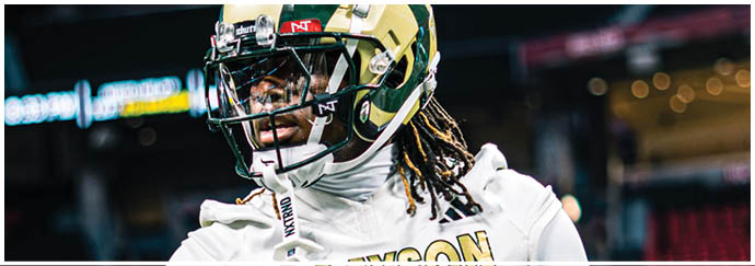 A person wearing a white sports jersey with the name “GRAYSON" and the number zero is standing in a stadium. Description generated by AI
