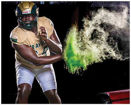 A person is hitting a red punching bag, causing a cloud of white and green powder to explode in the air against a black background. Description generated by AI