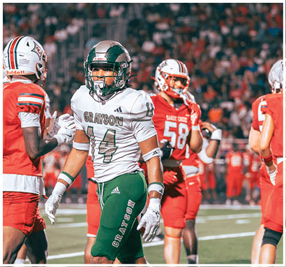 A group of people wearing football uniforms are on a field with one person in a white and green uniform standing in the center and others in red uniforms around them. Description generated by AI