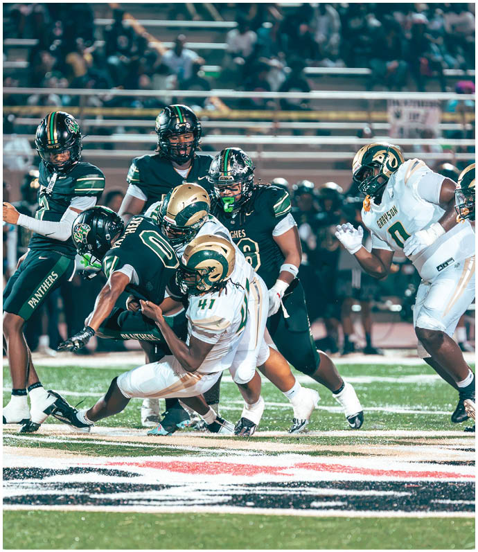 Adults in football uniforms are on a field with one player in red running and others in white and green celebrating or preparing to play. Description generated by AI