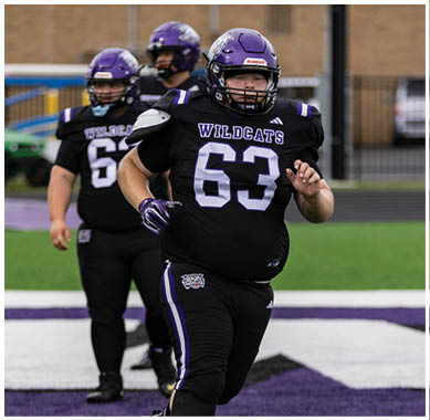 A football player running on the field. Description generated by AI