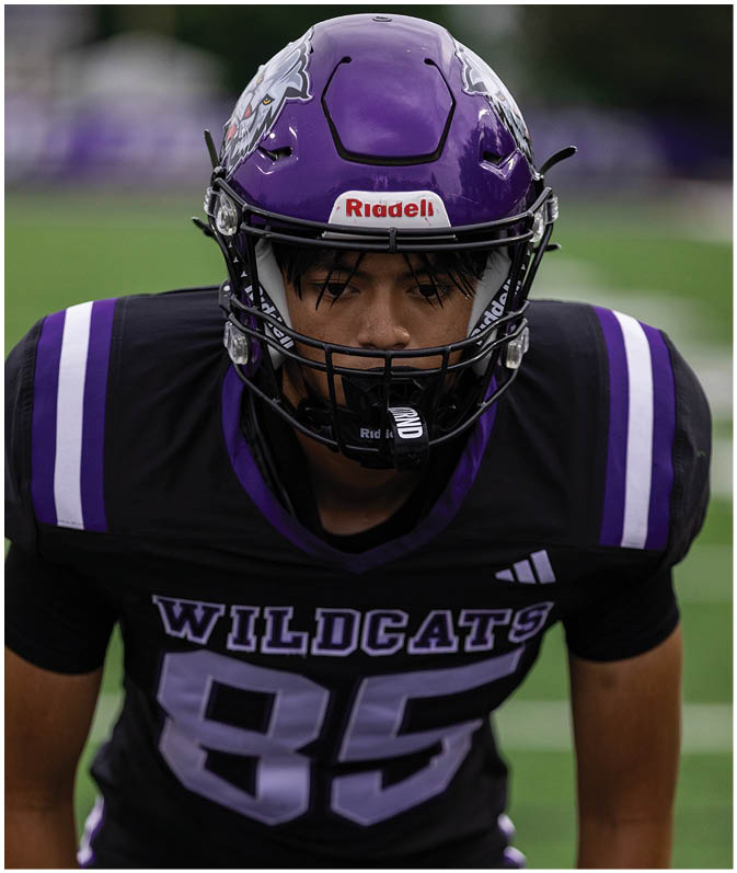 A group of football players wearing black and white uniforms. Description generated by AI