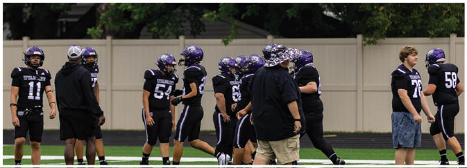 A group of football players on a field. Description generated by AI