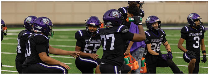 A group of football players on a field. Description generated by AI