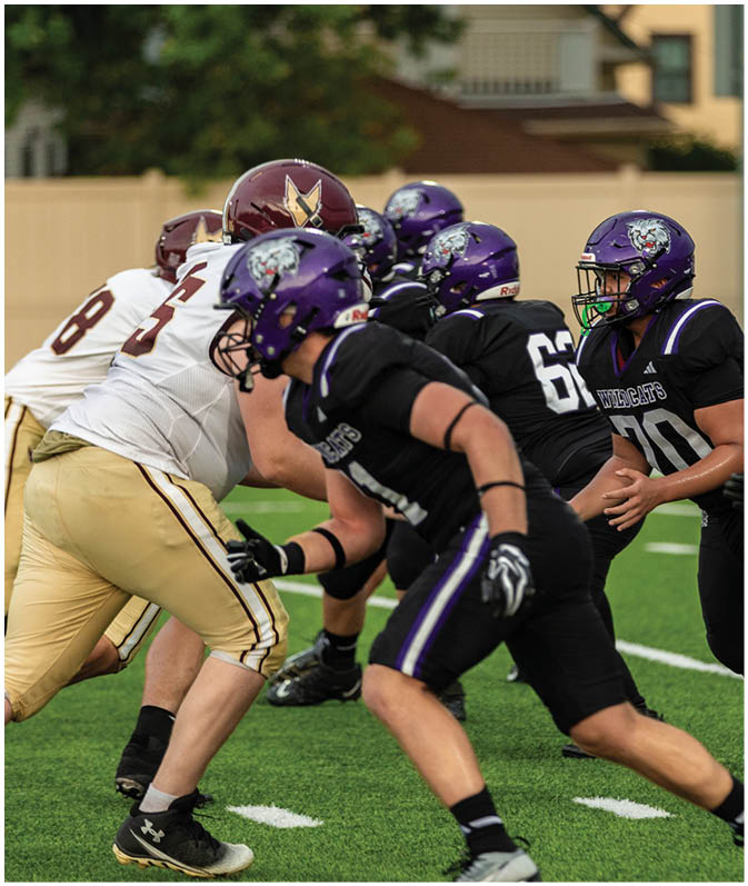 A group of football players wearing black and white uniforms. Description generated by AI