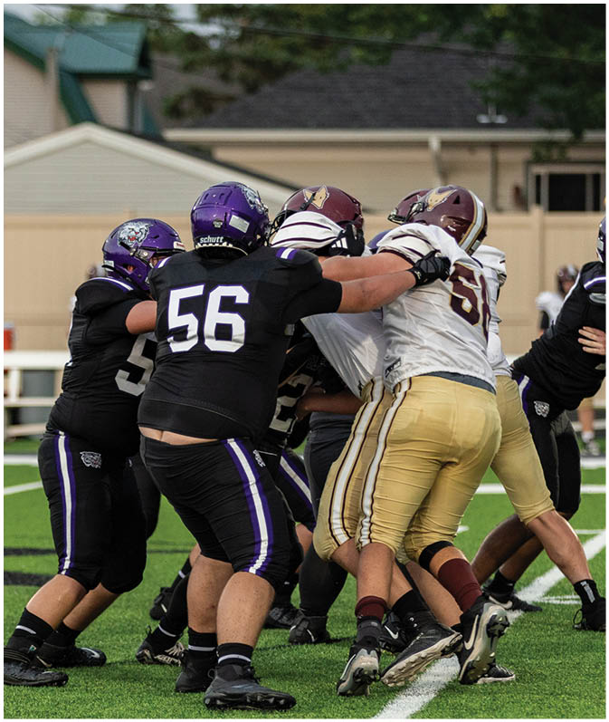 A group of football players wearing black and white uniforms. Description generated by AI