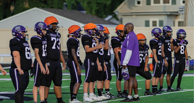 A group of people are kneeling on a field, possibly in a football game. AI generated content
