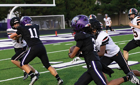 Two men wearing football uniforms are hugging each other on a field. AI generated content