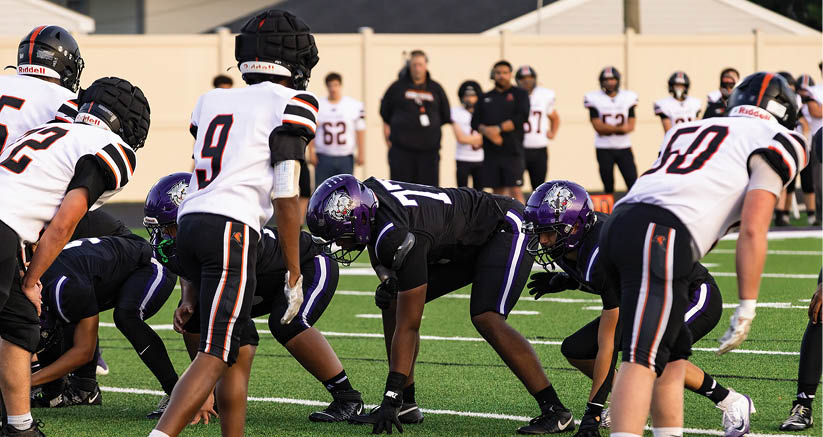 A group of people are kneeling on a field, possibly in a football game. AI generated content