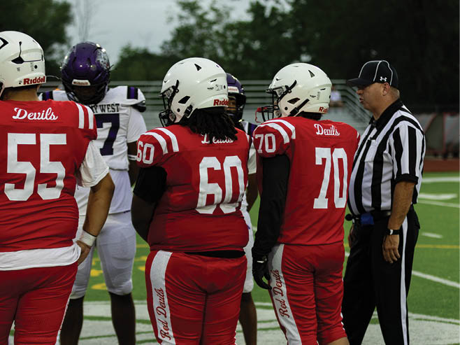 A group of football players in black and white uniforms are on the field. AI generated content