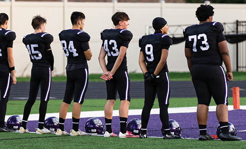 Two men wearing football uniforms are hugging each other on a field. AI generated content
