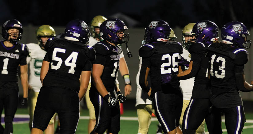 A group of people are kneeling on a field, possibly in a football game. AI generated content