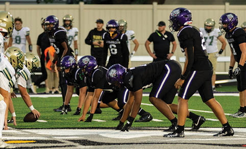 Two men wearing football uniforms are hugging each other on a field. AI generated content
