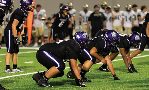 Two men wearing football uniforms are hugging each other on a field. AI generated content