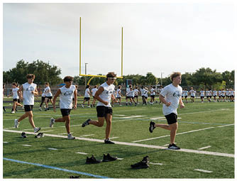 A group of people running on a field. Description generated by AI