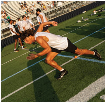 A man running on a football field. Description generated by AI