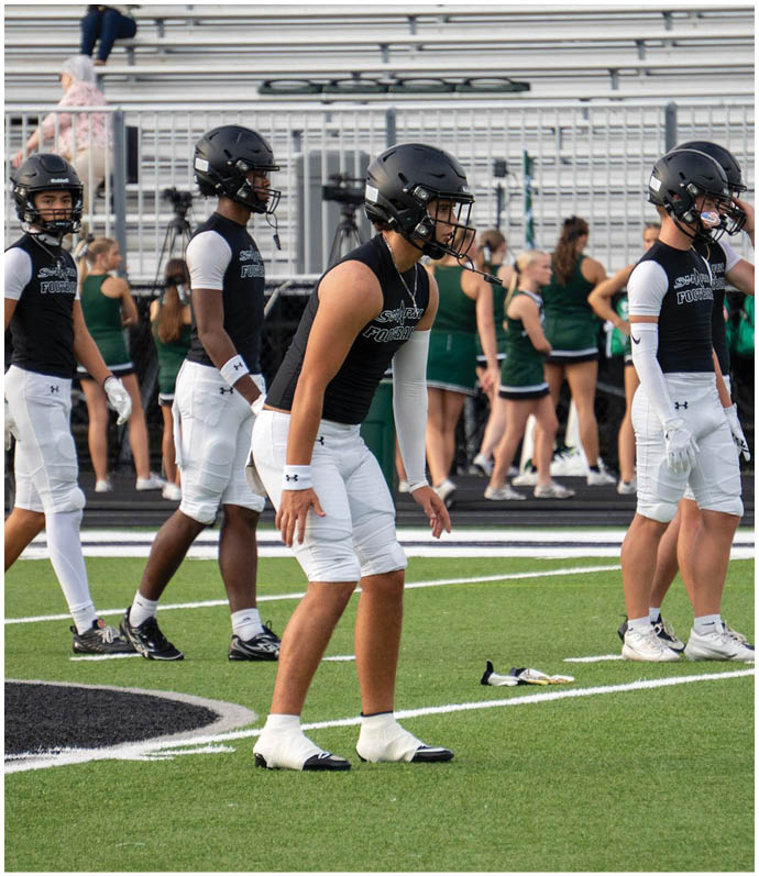 A group of football players on a field. Description generated by AI