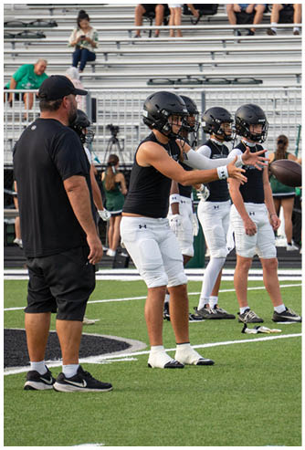 A group of football players on a field. Description generated by AI