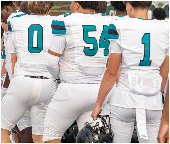 A group of football players wearing white uniforms. Description generated by AI
