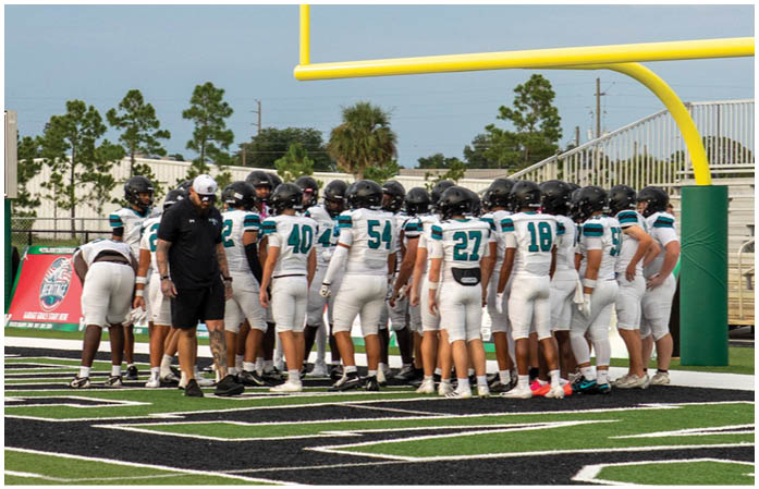 A football team is gathered around a goal post. Description generated by AI