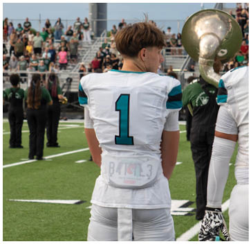 A football player wearing a white jersey with the number 1 on it. Description generated by AI