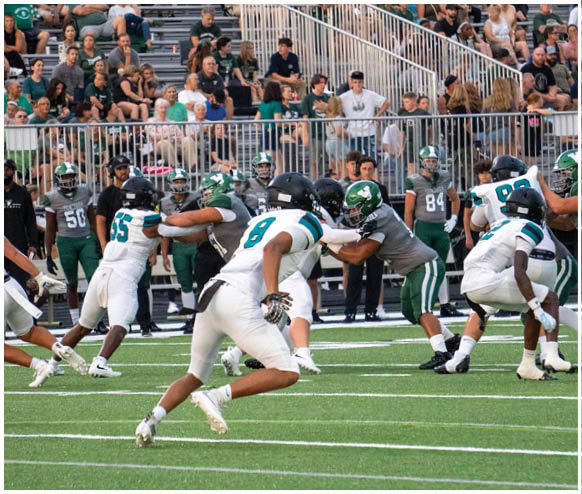 A football game is taking place with a player running on the field. Description generated by AI