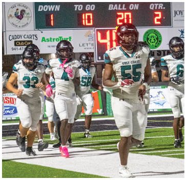 A football field with a green and white sign. Description generated by AI