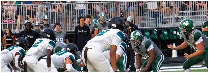 A football game is being played on a field with a crowd watching. Description generated by AI