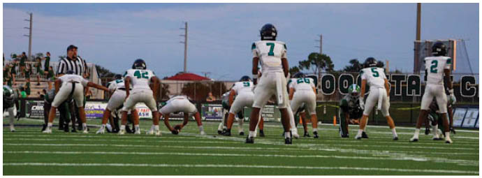 A group of football players on a field. Description generated by AI