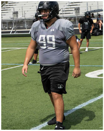 A football player wearing a grey jersey with the number 99. Description generated by AI