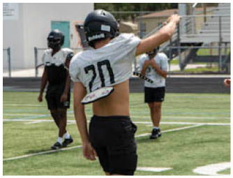 A football player in a white jersey with the number 70 on it. Description generated by AI