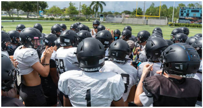 A group of football players wearing helmets and jerseys. Description generated by AI