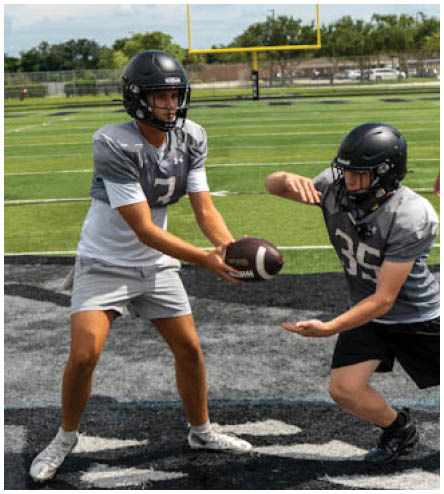 Two football players on a field. Description generated by AI