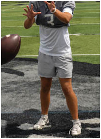 A man wearing a football helmet and holding a football. Description generated by AI