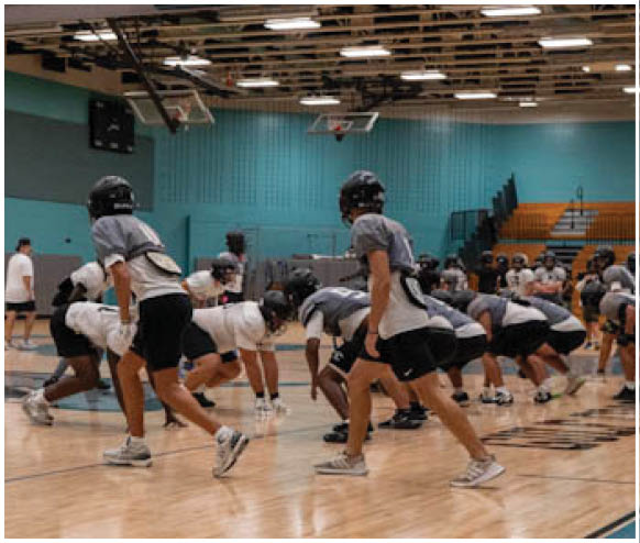 A group of football players on a court. Description generated by AI
