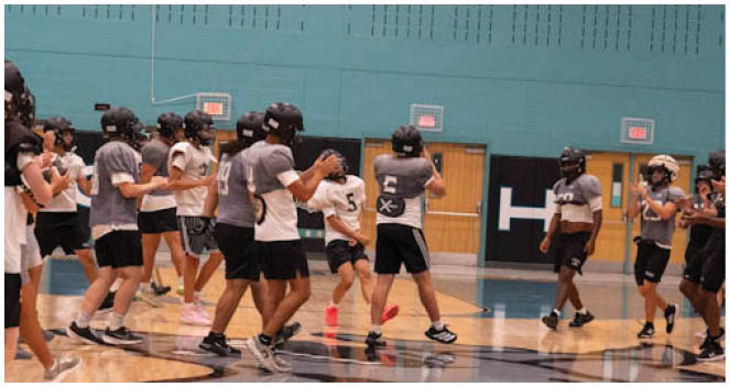 A group of people wearing helmets and playing basketball. Description generated by AI