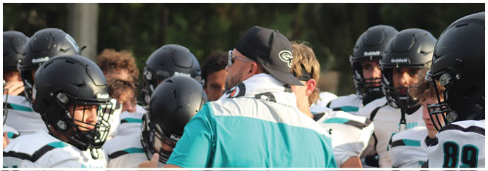 A group of football players wearing blue and white uniforms. Description generated by AI