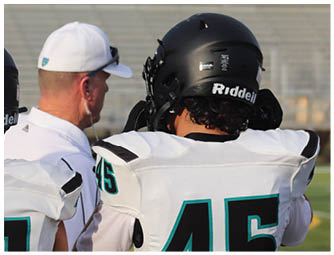 A football player wearing a white and blue jersey. Description generated by AI