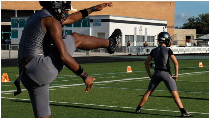 A football field with two men playing. Description generated by AI