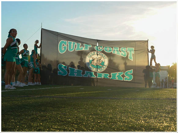 A group of cheerleaders are on a field. Description generated by AI
