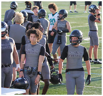 A group of football players walking on a field. Description generated by AI