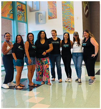 A group of women standing in a hallway. Description generated by AI