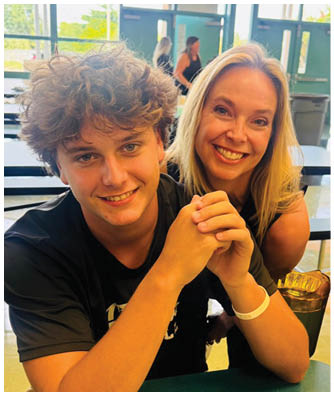 A man and woman sitting at a table with a green drink in front of them. Description generated by AI