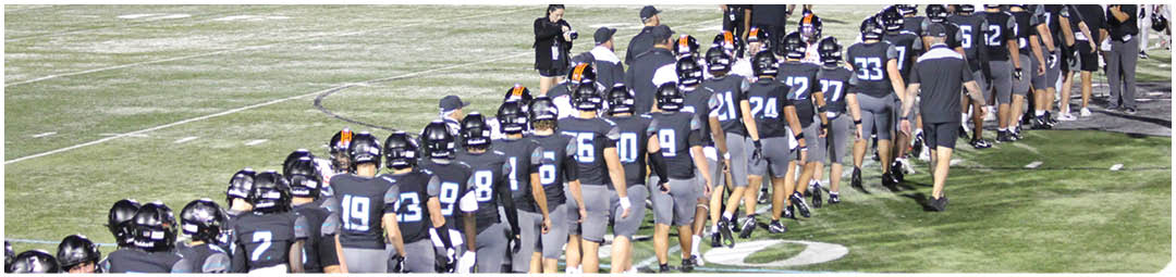A group of football players in uniforms. Description generated by AI