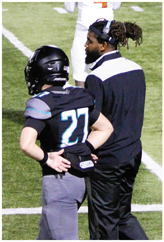 A man wearing a black helmet and a blue jersey. Description generated by AI